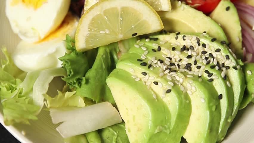 Avocado salad egg, tomato, onion, green leaf salad vegetable dish natural tasty snack fresh gourmet food background on the table rustic top view copy space keto and paleo diet vegan and vegan food