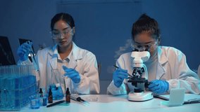 Female researchers collaborating at microscope, analyzing test tube samples in cutting edge laboratory setting with advanced scientific equipment - Powered by Shutterstock - Get 15% off with code: PIKWIZARD15