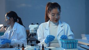 Professional female scientist performing microscope research, collaborating with colleague in modern laboratory, focusing on precise scientific analysis - Powered by Shutterstock - Get 15% off with code: PIKWIZARD15