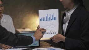 Professional business team collaborating on financial analysis, carefully reviewing paper charts and digital tablet data in modern corporate office workspace - Powered by Shutterstock - Get 15% off with code: PIKWIZARD15