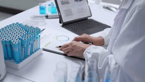 Medical research scientist carefully analyzing scientific data on digital tablet, surrounded by test tubes and advanced laboratory equipment, investigating innovative healthcare solutions - Powered by Shutterstock - Get 15% off with code: PIKWIZARD15