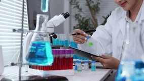 Advanced laboratory technician carefully analyzing scientific samples through digital tablet interaction while conducting precise medical research in contemporary sterile workspace - Powered by Shutterstock - Get 15% off with code: PIKWIZARD15