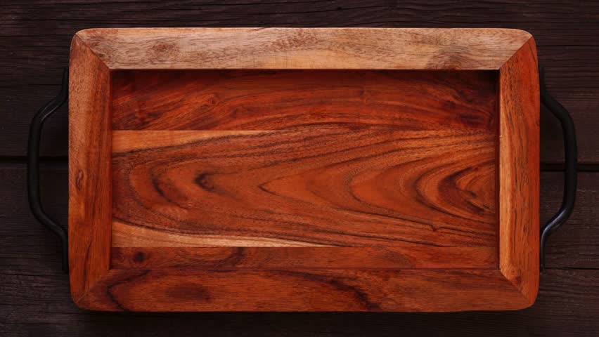 Autumn pie theme dessert board. Top down view stop motion placement video over a dark wood background. Pumpkin, apple and pecan mini pies, with whipped cream, caramel and fruit.