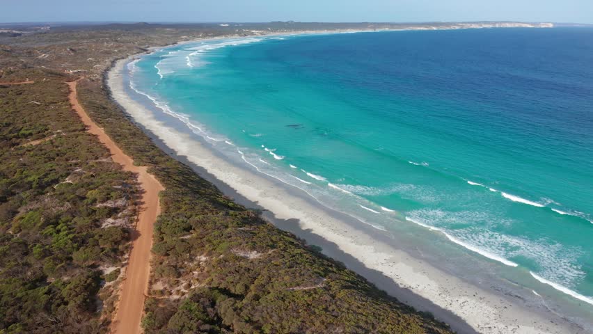 Drone aerial of surf waves, clear water and white sand at Vivonne Bay, Kangaroo Island, South Australia