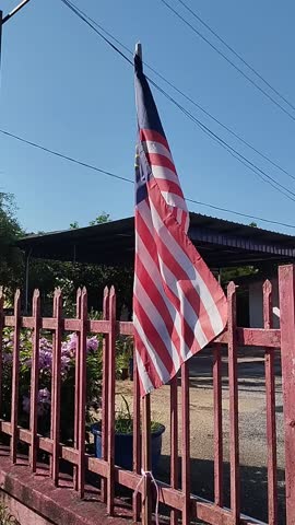 The national flag of Malaysia (Jalur Gemilang, or "Stripes of Glory") against the sky, blown in the wind