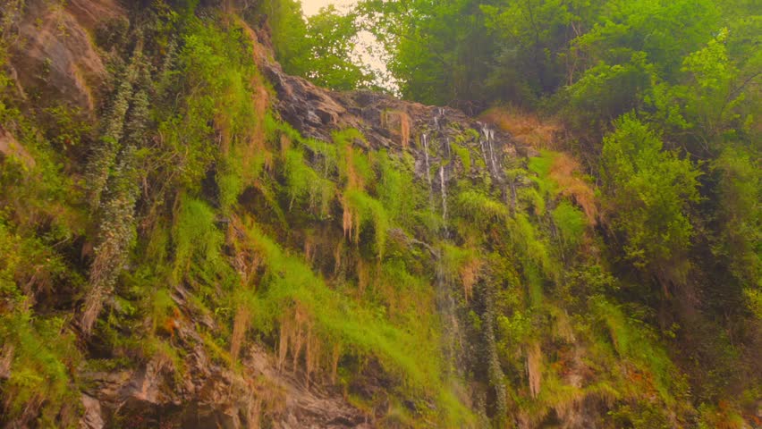 Small dwindling waterfall and stream, symbolizing the visible effects of climate change and drought on nature's delicate water resources.