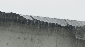 Streams of rain water running off a corrugated metal roof in a torrential rain storm - Powered by Shutterstock - Get 15% off with code: PIKWIZARD15