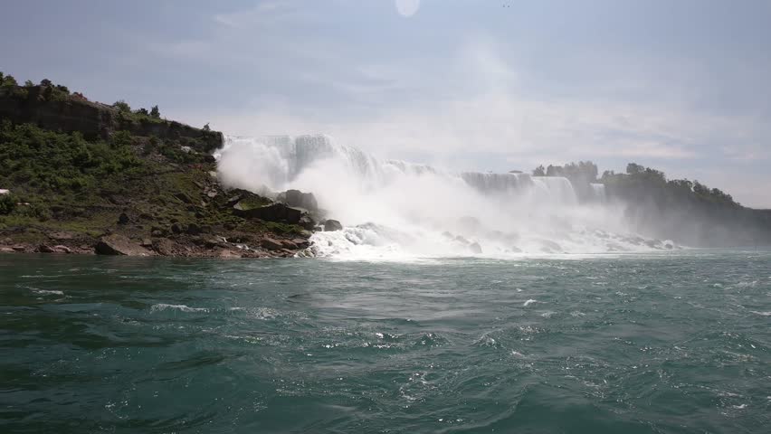 DOLLY SHOT - The Niagara Falls (American Falls and Bridal Veil Falls) seen from a boat tour on the Niagara River in Ontario, Canada.