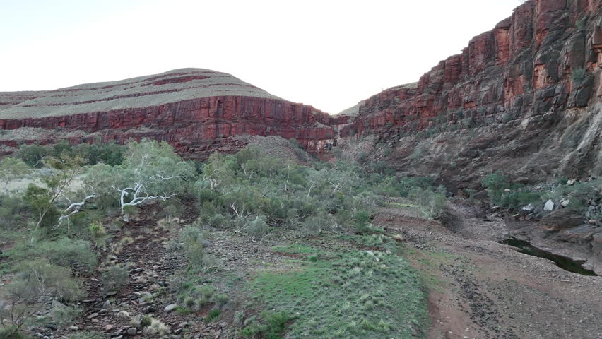 aerial drone shot of a remote bush camp along secluded George river in the beautiful red rolling hills of Millstream Chichester National Park, pilbara shire in West Australia.