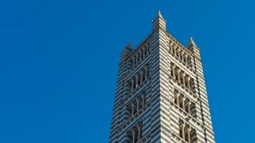 Siena cathedral bell tower: majestic marble stripes against blue sky. Siena cathedral bell tower, with its distinctive white and dark green marble stripes, stands tall against a vibrant blue sky - Powered by Shutterstock - Get 15% off with code: PIKWIZARD15