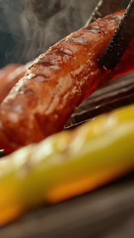 Ultra slow-motion shot of meet sausages getting cooked on the barbeque grill. Close-up footage