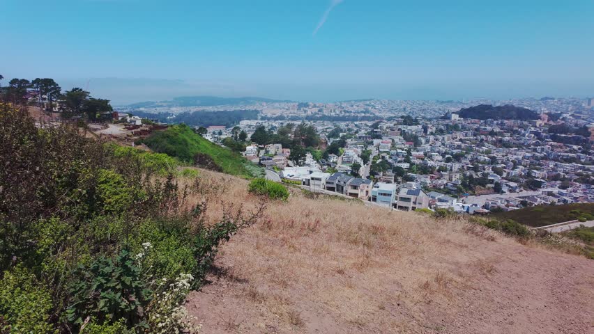 Panoramic cityscape of San Francisco seen from Twin Peaks, California, USA. Wide view of urban skyline, residential neighborhoods and bay under clear summer sky