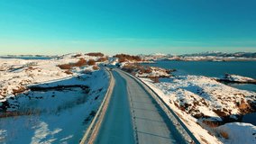 aerial drone footage showcases the iconic Atlantic Ocean Road Atlanterhavsveien in Norway, transformed into a winter wonderland by a blanket of pristine snow. - Powered by Shutterstock - Get 15% off with code: PIKWIZARD15