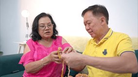 Senior woman knitting colorful yarn and tries to teach her husband how to knit on the sofa - Powered by Shutterstock - Get 15% off with code: PIKWIZARD15