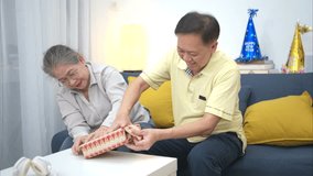 On a holiday, an elderly couple enjoys wrapping gifts to give to friends on their birthdays - Powered by Shutterstock - Get 15% off with code: PIKWIZARD15