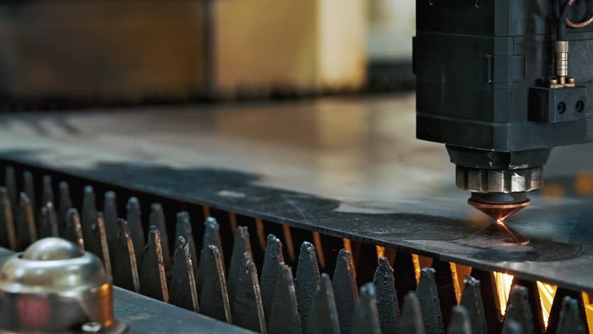 Industrial CNC laser cutting machine processing metal sheet with bright sparks and plasma light. High precision manufacturing technology in modern metalworking industry. Tech Background Close-up 4k