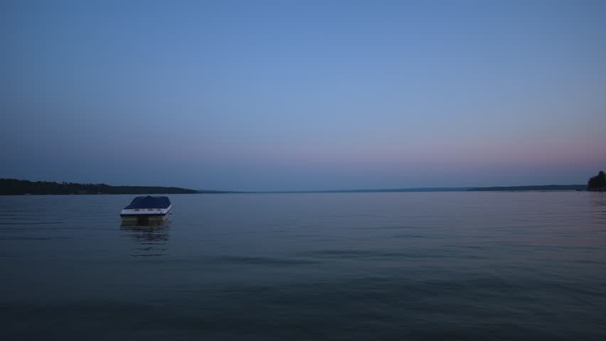 Boat floating on the lake during sunset (blue hour)