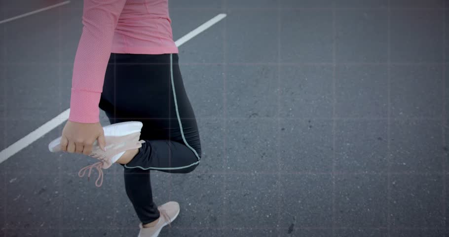 Mid adult woman lifting foot performing quad stretch on road transitioning into walking for fitness. Athletic, wellness, outdoor, active, fitness, determination, minimalist