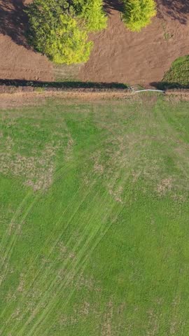 Vertical top-down aerial drone shot of 18-hole miniature golf course. The camera pans across fairways, bunkers, greens, rough and water hazards.