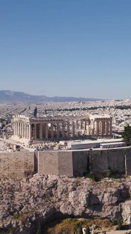 Vertical drone orbiting the majestic Parthenon in Athens, Greece, highlighting its classical architecture atop the Acropolis