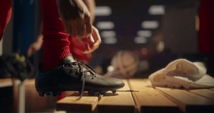 Close Up Footage of Player's Hands Pulling the Laces Tight on a Pair of Black Soccer Cleats. Stadium Locker Room Filled with Team Spirit as Football Players Get Ready for Kickoff - Powered by Shutterstock - Get 15% off with code: PIKWIZARD15