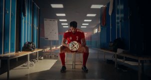Portrait of a Handsome Young Male Sitting on a Bench in a Locker Room, Playing with a Soccer Ball. Man Wearing a Red Sports Uniform, Looking at Camera with a Confident Smile - Powered by Shutterstock - Get 15% off with code: PIKWIZARD15