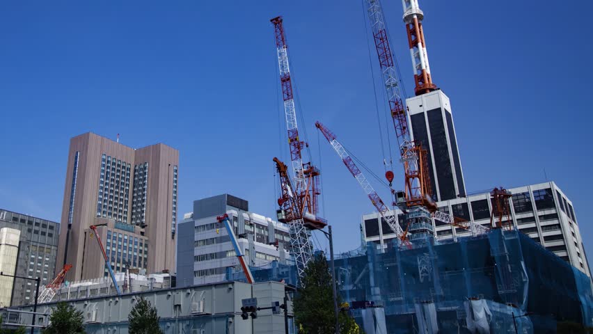 A timelapse of moving crane at the under construction in Tokyo wide shot panning