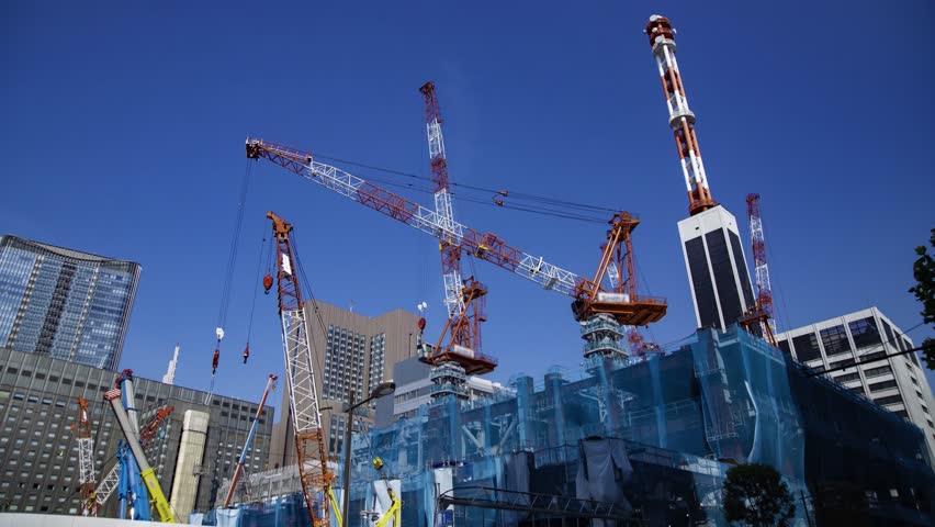 A timelapse of moving crane at the under construction in Tokyo wide shot tilt