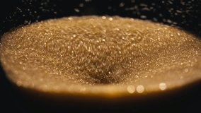 Close-up photograph of golden glittering sand leaking out of an hourglass. - Powered by Shutterstock - Get 15% off with code: PIKWIZARD15