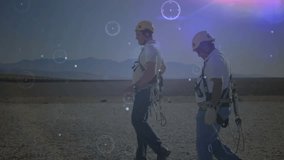 Walking side by side during wind turbine inspection workers generating drifting circle overlays. Industrial, teamwork, technology, landscape, exploration, innovation, safety - Powered by Shutterstock - Get 15% off with code: PIKWIZARD15