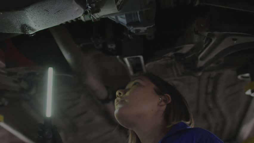 Automotive technician inspecting undercarriage with LED, starting data overlay and flagging faults. Mechanic, workshop, industrial, diagnostics, maintenance, technology, engineering - Powered by Shutterstock - Get 15% off with code: PIKWIZARD15