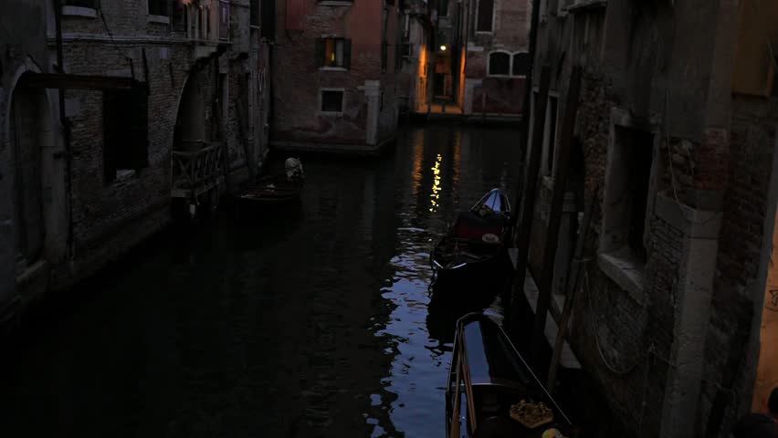 Venice evening canal with gondolas and glowing windows