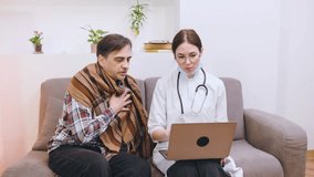 A doctor shows medical information on a laptop to a senior patient sitting on a couch at home, creating a relaxed atmosphere for their consultation. - Powered by Shutterstock - Get 15% off with code: PIKWIZARD15