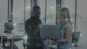 Female coworker approaching male with laptop in office, showing network overlay and reviewing data. Collaboration, teamwork, technology, modern, professional, communication, innovation - Powered by Shutterstock - Get 15% off with code: PIKWIZARD15