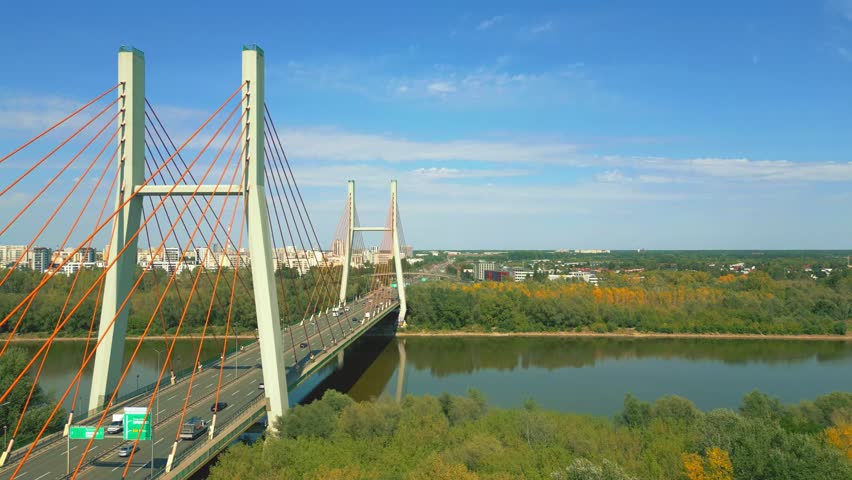 Stunning cinematic shots of Warsaw’s Siekierkowski Bridge capture its modern architecture, glowing lights, and reflections over the Vistula, showcasing the city’s dynamic beauty."
