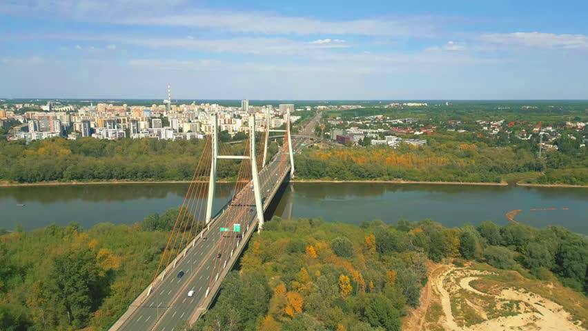 Stunning cinematic shots of Warsaw’s Siekierkowski Bridge capture its modern architecture, glowing lights, and reflections over the Vistula, showcasing the city’s dynamic beauty."