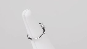 Close-up of a square diamond ring on a jewelry stand, rotating on a white backdrop. - Powered by Shutterstock - Get 15% off with code: PIKWIZARD15