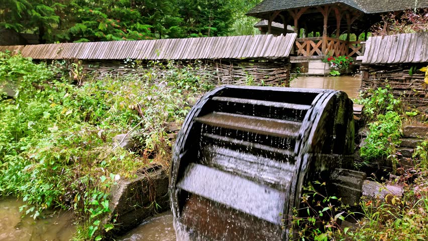 Traditional wooden mill wheel turning by water power from stream