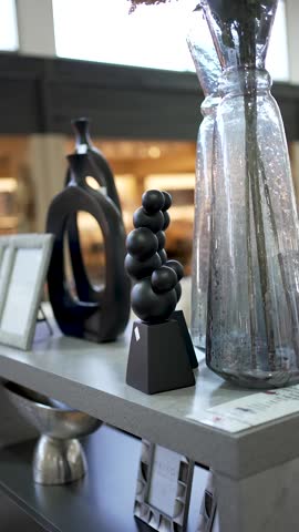 Unique sculptures and stunning vases are displayed in a stylish showroom, providing an elegant backdrop for art lovers. The clean design creates a modern atmosphere for appreciation.
