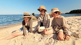 A mother and children traveling to the sea, vacationing with children in nature, searching for something in the sand and looking through a magnifying glass, exploring fossils in the sand - Powered by Shutterstock - Get 15% off with code: PIKWIZARD15