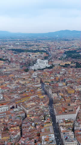 Epic 4K vertical aerial video of Rome featuring Vittoriano monument, Colosseum, and historic streets. Stunning drone footage capturing Italian capital cityscape with mountains, ideal for mobile reels.
