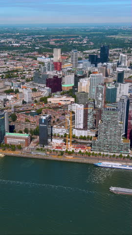 Spectacular 4K vertical aerial video of Rotterdam skyline with modern skyscrapers, waterfront, and ships. Stunning drone footage capturing Dutch city architecture and harbor, perfect for mobile reels.