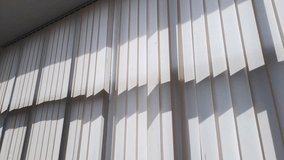 Sunlight streams through vertical blinds, creating a dynamic pattern of light and shadow on the ceiling. This video captures a calm, modern atmosphere perfect for themes of tranquility and design. - Powered by Shutterstock - Get 15% off with code: PIKWIZARD15