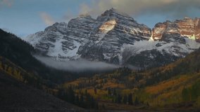 Sunrise Maroon Bells 14er peak Colorado most photographed panoramic nature landscape fall autumn golden hour first light on Rocky Mountains fog clouds snow White River Forest Aspen Snowmass Trees pan - Powered by Shutterstock - Get 15% off with code: PIKWIZARD15