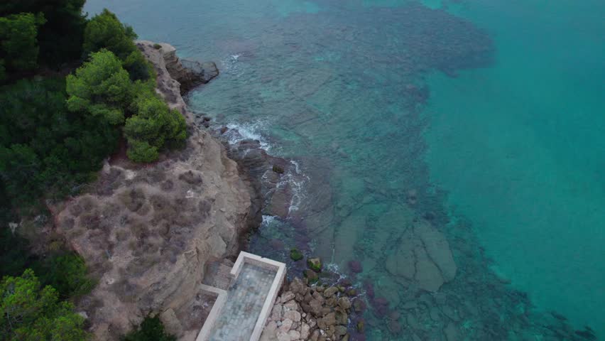 Cove With Clear Blue-Green Water And Rocky Shorelines In Calpe, Costa Blanca, Alicante, Spain. Aerial Shot
