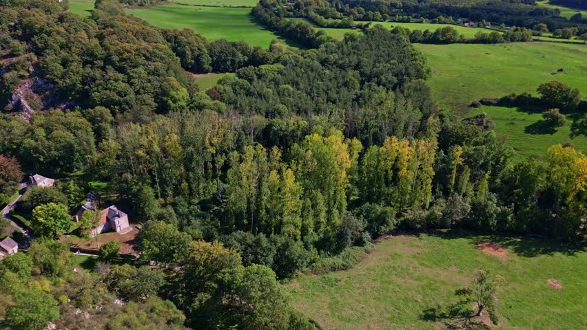 Lush green forest landscape near Sainte Suzanne, early autumn colors, aerial overview