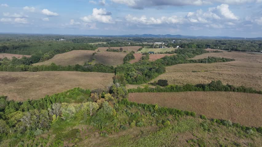 Hilly forest landscape on sunny day in late summer season. Rural area of American countryside. Peaceful scene . Aerial wide shot.