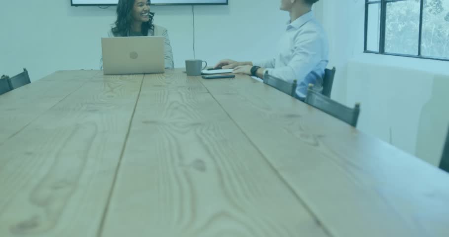 Coworkers exchanging greeting at business meeting table, causing floating topic icons, man exiting. Professional, collaboration, innovation, networking, modern, teamwork, productivity