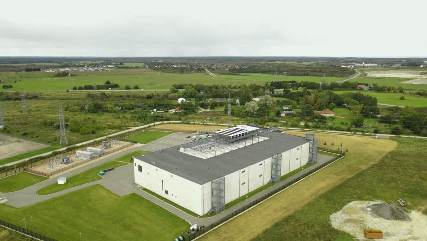 Aerial drone revealing shot of a data center in sunny countryside for AI, Algorithms, data, Intelligent Systems, cryptography and security and quantum computing, Server space.