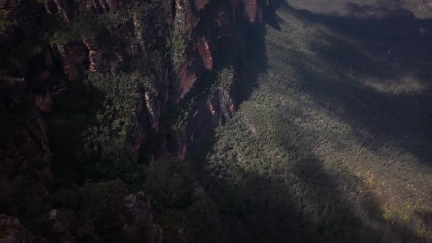Cinematic drone pullback over narrow mountain corridors surrounded by dense gum trees and cliffs, Blue Mountains NSW Australia
